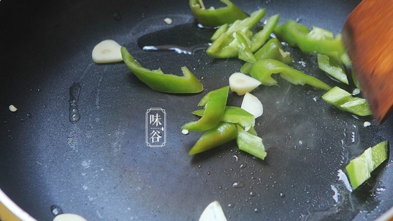 南瓜花炒鸡蛋,锅内放油,放入蒜片和青椒翻炒出香味;