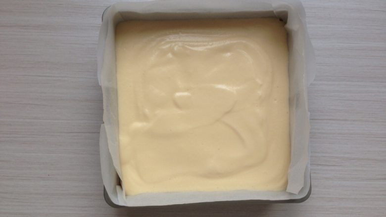 超柔软的棉花蛋糕,拌好的蛋糕糊倒入到铺了油纸的,18CM方型模具里。震动一下烤盘,使蛋糕糊里的大气泡震出来。