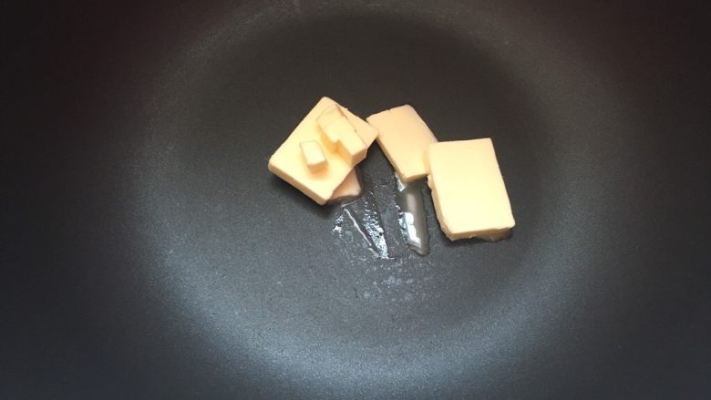 冰爽绿豆糕,黄油切片入不粘锅内,加热至融化。