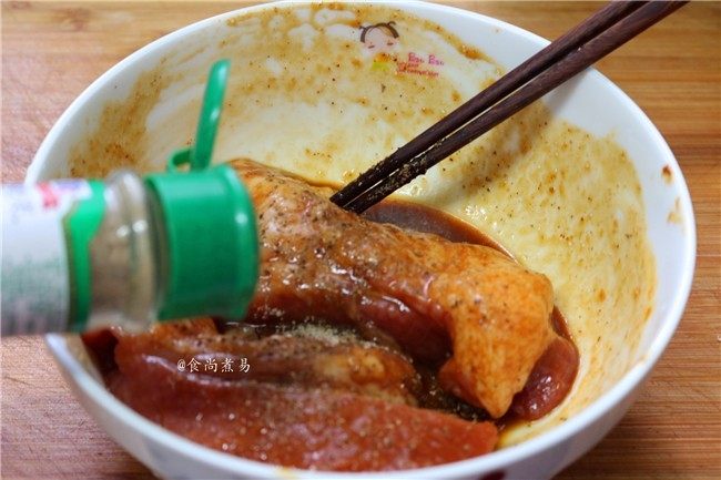 私房蜜汁叉烧肉,倒入香蒜粉,戴上一次性手套,给猪肉按摩一两遍,搅拌均匀腌料