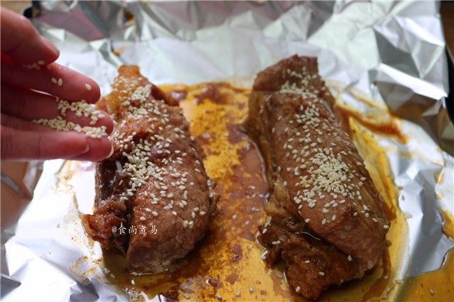 私房蜜汁叉烧肉,在叉烧上撒一层白芝麻,拿走覆盖在叉烧上面的锡纸