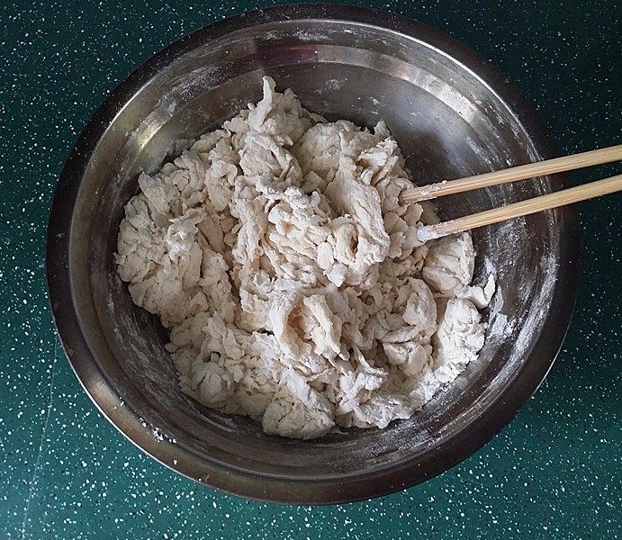 桑茸黑芝麻酥烧饼,先做油皮:将主料倒入盆中搅拌成絮絮状