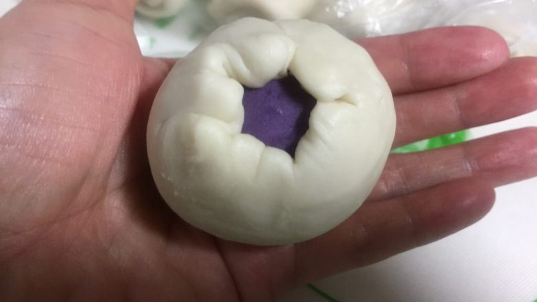 酥皮点心紫薯酥,放在左手掌心,用右手虎口慢慢往上推包住紫薯。
