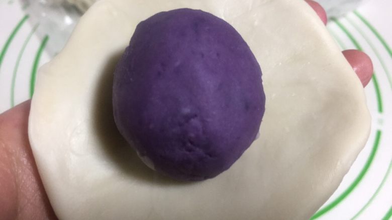 酥皮点心紫薯酥,擀成圆形的面片,中间放上一个紫薯馅。