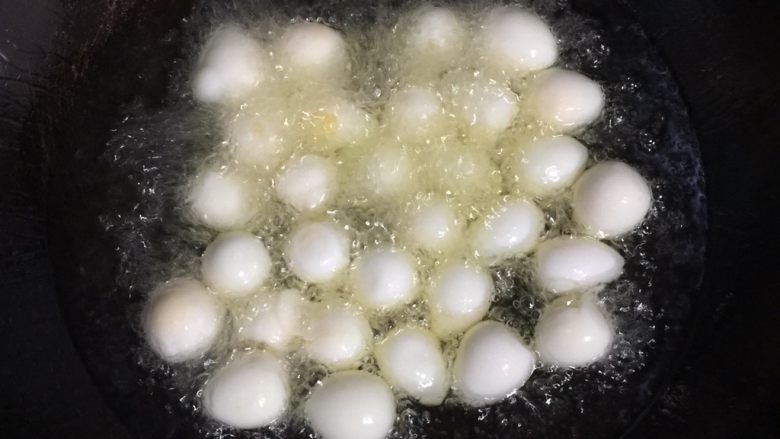 糖醋虎皮鹌鹑蛋,锅中放入适量的油,烧至六成热时,放入鹌鹑蛋中小火慢炸。