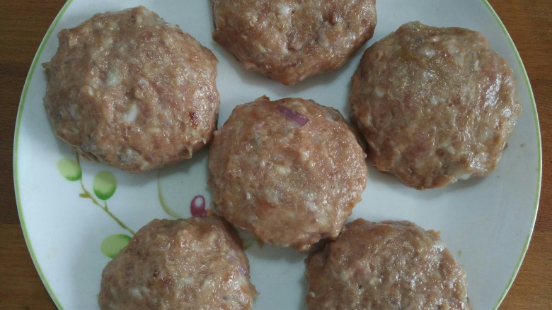 鹌鹑蛋蒸肉饼,平分成六份,取一份用两只手互抛摔打成饼状,同样的方法做好全部,摆盘