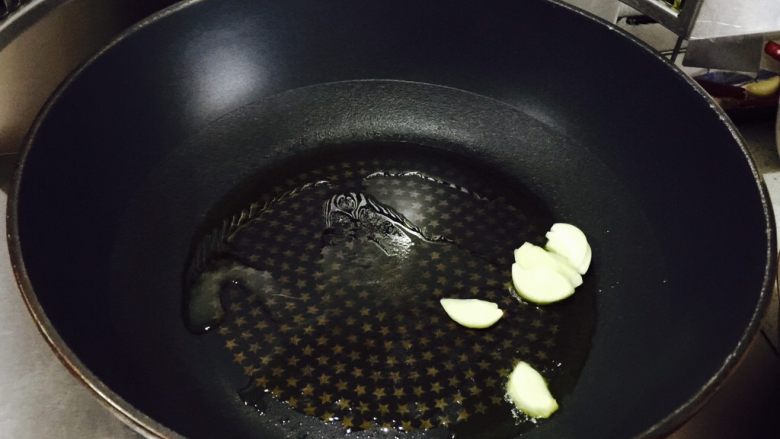 蟹粉煮干丝,炒锅加热后入油,下蒜片,炒香