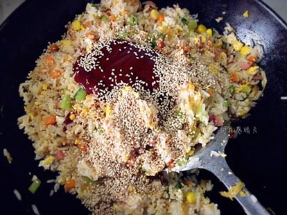 韩式焗饭,将菜、蛋及饭翻炒均匀,放入辣酱及白芝麻翻炒均匀。
