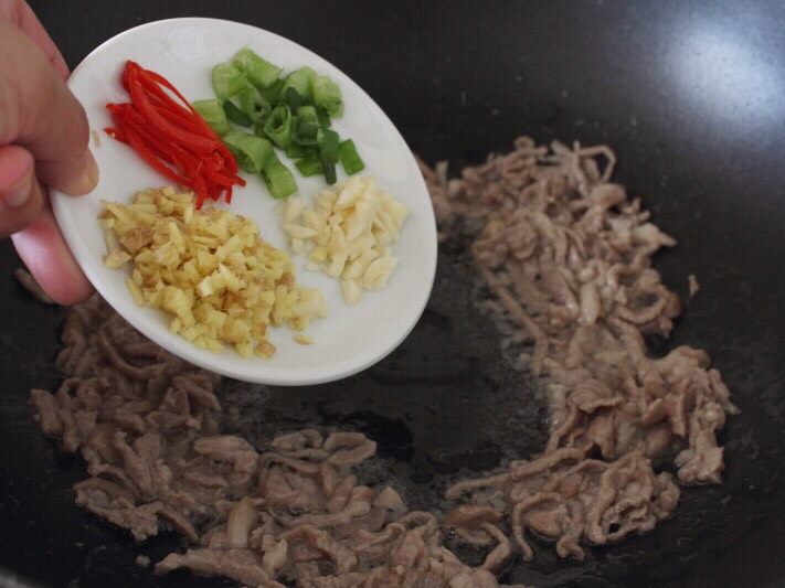 魚香肉丝,
6.将肉丝拔到边上,下葱、姜、蒜、红泡椒,焙出香味。