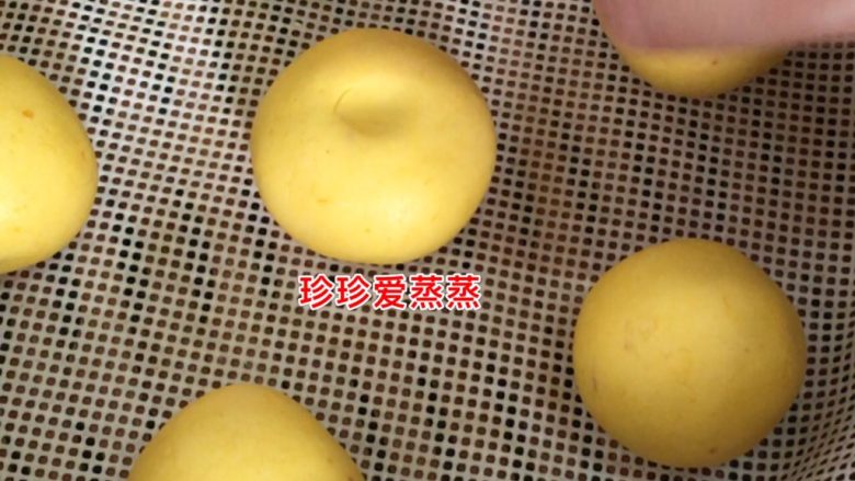 南瓜糯米紫薯糕,硅胶垫刷一层植物油,将揉圆的面团放在蒸笼里,用食指在面团顶部轻轻按压出指印