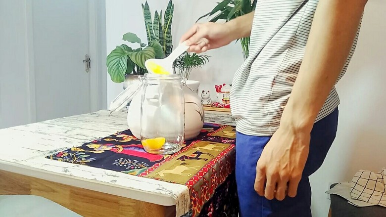 自制桃罐头,放凉后,用勺子把油桃捞到密封罐中,最后把锅里的糖水也倒进去。