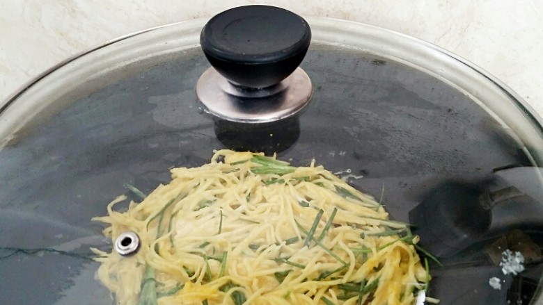 香葱土豆饼,盖上锅盖,小火加热。