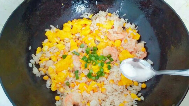 玉米虾仁蛋炒饭。,撒上香葱,盐调味,即可出锅。