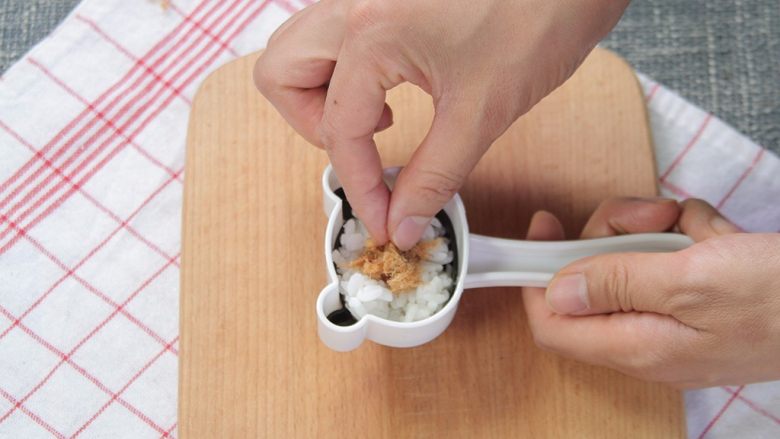 让熊孩子爱上吃饭的熊猫饭团,在模具中放上一层米饭,再放上一层肉松,最后放上米饭,用模具压出小熊猫的样子