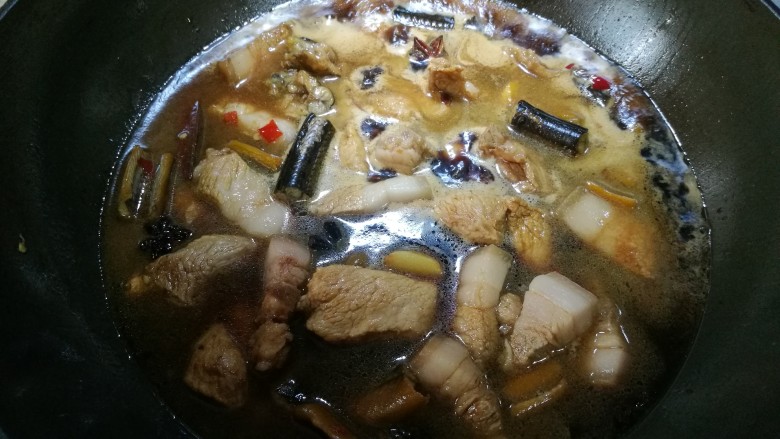 黄鳝烧肉,翻拌均匀后移入适量的水,转中小火。盖上锅盖。