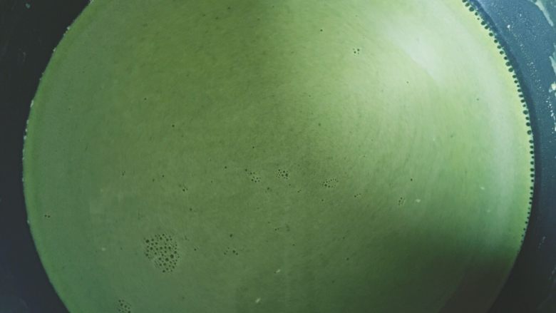 椰蓉抹茶奶豆腐—无需烤箱系列,抹茶溶液中火加热至微微沸腾,转小火倒入澄粉液,一边倒入一边用蛋抽搅拌均匀