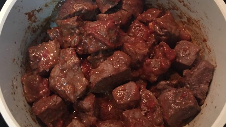 紅酒燉牛肉(一鍋到底),將牛肉撥到鍋邊,中間空出來放入蒜頭,剖開面朝下略煎,再放入蕃茄糊略炒一下後,拌開,讓牛肉都沾到蕃茄糊,