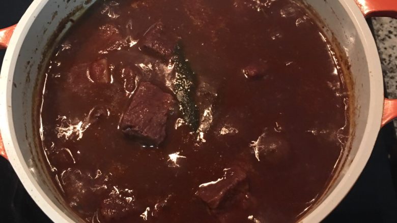 紅酒燉牛肉(一鍋到底),一小時後,先撈出蒜頭,用濾網將蒜肉壓成泥,除去蒜皮,將蒜泥混入湯汁中;試味道用鹽調整後,