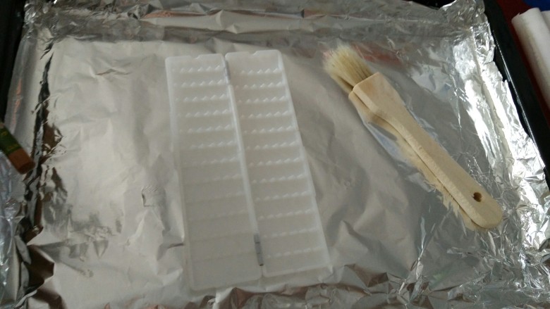 烤箱烤肉串(炒鸡好吃),烤盘铺上锡纸后,准备开始穿串儿,没有买锡纸直接放烤盘上也行的,就是刷的时候费劲点儿,