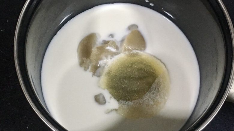 椰香抹茶糕,把牛奶,泡好的吉利丁粉,麦芽糖,细砂糖,白豆沙倒入奶锅。