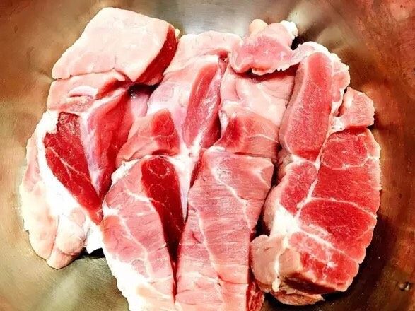 电饭锅版叉烧肉,用刀将肉切成大块放入盆内；