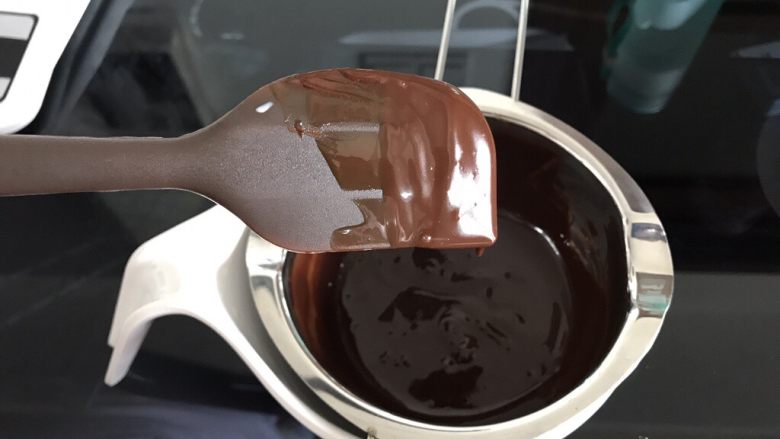 巧克力淋面蛋糕,提起刮刀,甘纳许流成细线状就是可以淋面的状态。