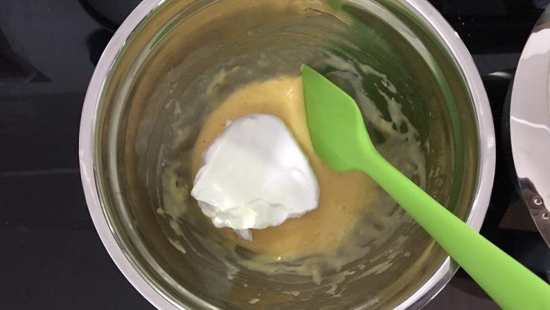 巧克力淋面蛋糕,取三分之一蛋白霜加入蛋黄糊,用翻拌的手法翻拌均匀。