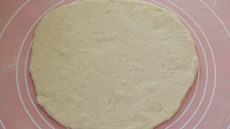 先煎后烤披萨,13.取一份面团抻成大饼,抻的水平有限就用擀面杖擀几下,就这样不规则的就好,不要擀的太圆,这就是这种披萨的特殊之处。