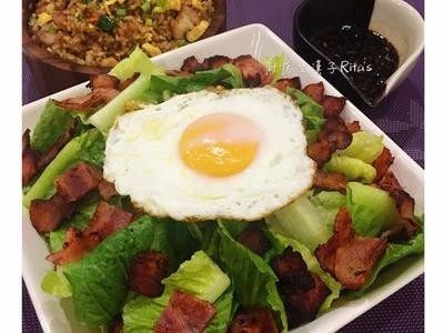 培根美生菜沙拉佐紅酒醋醬,美生菜裝盤後在上面撒上培根,最後放上煎蛋,食用時再淋上紅酒醋油蔥醬即可。