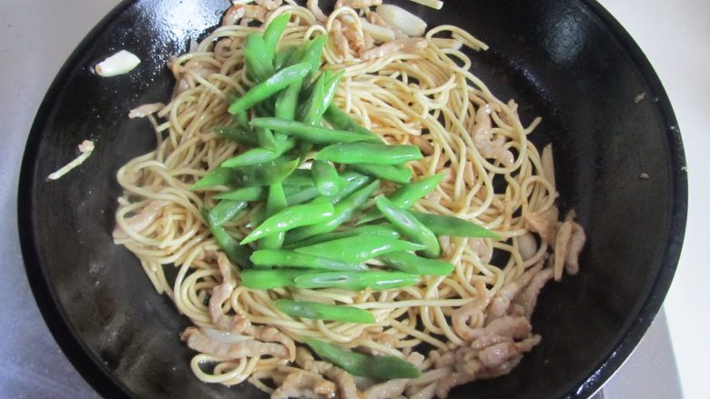 四季豆肉丝炒面,再放入焯好的四季豆丝进去翻炒;