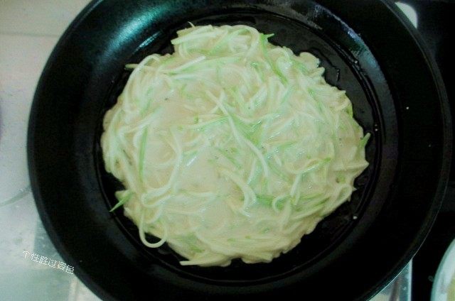 西葫芦糊塌子,将搅拌好的面糊盛一勺倒入锅内,用铲子摊平,不要太厚,薄一点好吃
