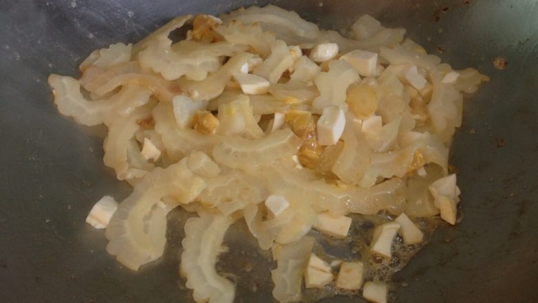 苦瓜炒鹹蛋,感覺苦瓜都變色後再加入鹹蛋丁，拌炒後稍微調味即可上菜。