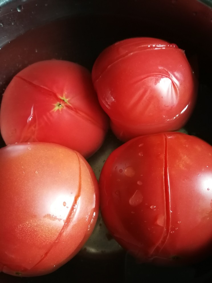 番茄🍅牛腩煲,炖牛腩的时候开始准备<a style='color:red;display:inline-block;' href='/shicai/ 59'>番茄</a>。洗净后的<a style='color:red;display:inline-block;' href='/shicai/ 59'>番茄</a>顶部轻轻划十字刀，然后加入开水浸烫一会儿后，就非常容易去皮了。