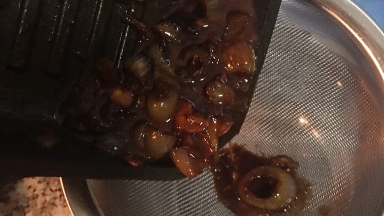 香煎厚切帶骨豬排佐蒜香黃芥末醬,挑出青豆仁,放到要裝醬汁的容器中,接著將鍋子裡的其他食材用濾網過篩,