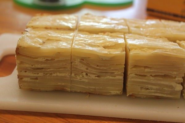 马铃薯千层方块 Potato Pavé,从烤模取出马铃薯千层块,去掉烤盘纸,将马铃薯千层块切成8块立体方块。