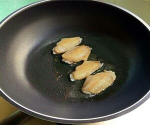 甜甜的可乐鸡翅,3.锅内放少许油烧热,放入鸡翅,煎至外皮两面泛黄。