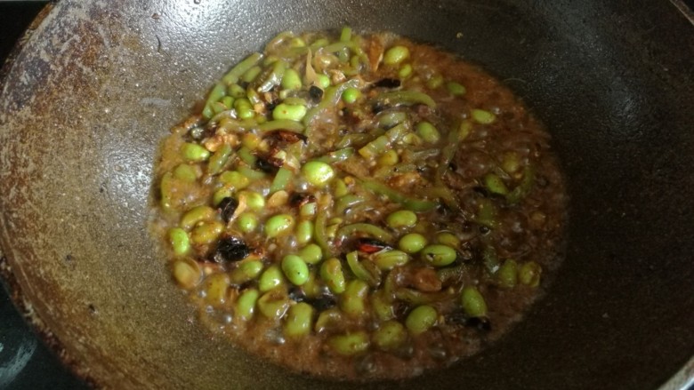 蛤蜊三吃,加入生抽,料酒及少许蛤蜊汤汁,大火翻炒,直至毛豆酥软。