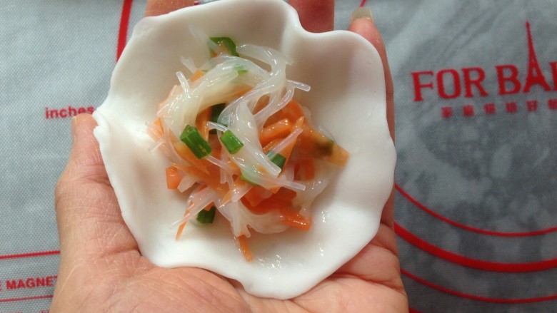 粉丝水晶饺,搓成长条,分成每份大概是23克左右的剂子,用擀面杖压成圆形粉皮,中间放入馅料。
