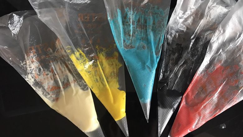 哆啦A梦彩绘蛋糕卷,面糊按照颜色多少分成五份调色,黑色描边部分用竹炭粉调色,白色部分用原色,其余用色素调色,装入裱花袋。