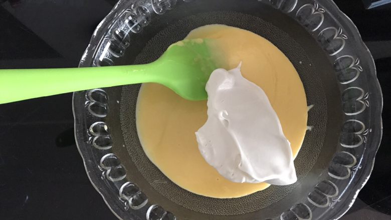 哆啦A梦彩绘蛋糕卷,将三分之一蛋白霜加入蛋黄糊,用翻拌的手法翻拌均匀。