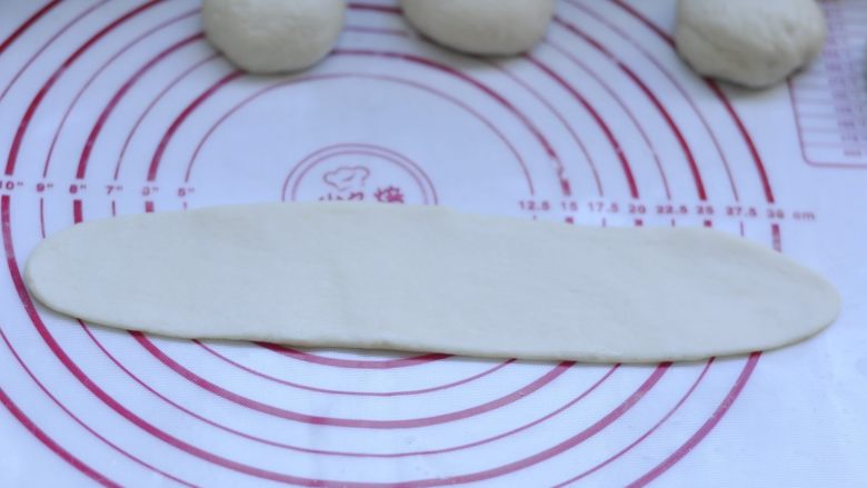 萌萌的小兔面包,8、取一块按扁,擀成牛舌状 长度约25cm 宽度7左右