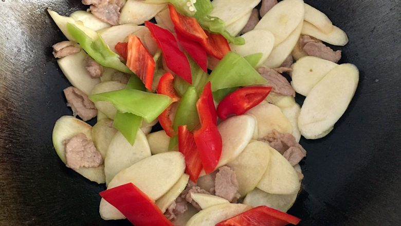 茭白炒肉片,放入切好的青椒和红尖椒,放盐和蚝油