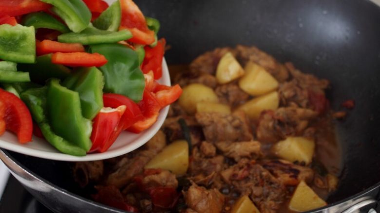 大盘鸡,11.水烧的差不多的时候,鸡肉已烂,将切块的青红椒入锅。