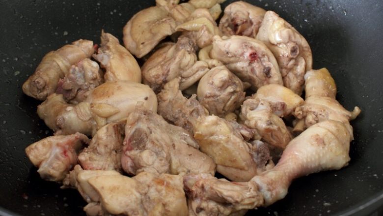 大盘鸡,4.上干锅,中火炒干鸡块的水分,炒出油,然后盛出,洗去污沬备用。