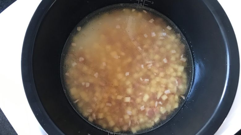 荠菜冬笋饭,再将炒制过的培根和冬笋丁倒进锅中,并稍稍搅拌一下,开始烹饪