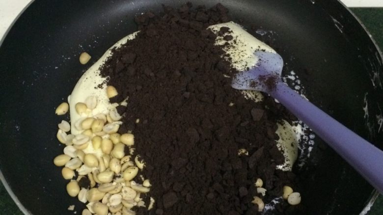 奥利奥花生牛轧糖,关火,加入花生和奥利奥饼干碎,迅速翻拌均匀,用手摸着干而不粘手即可。