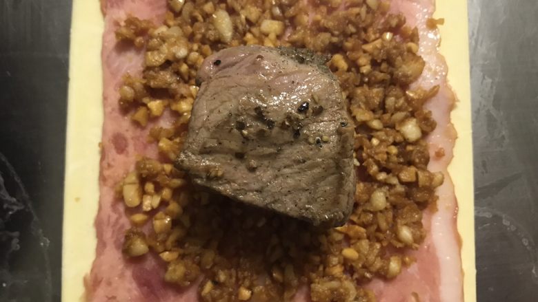 惠灵顿牛排,铺上蘑菇酱,放上牛肉块。