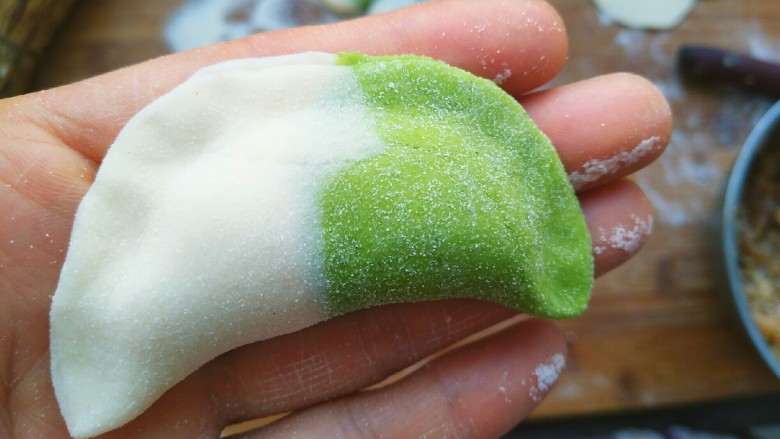 元宝饺子,拿一个水饺皮放入早起已调好备用的水饺馅,放入,然后对折捏起来