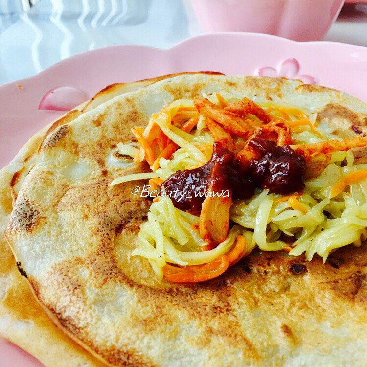 快手版老北京春饼（土豆丝卷饼）,取一张薄饼，加适量土豆丝，也可以再加些小咸菜，最后放一小勺黄豆酱