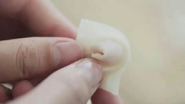 快手小馄饨,馄饨皮里放入少许肉馅,对折后两个角向内折叠。